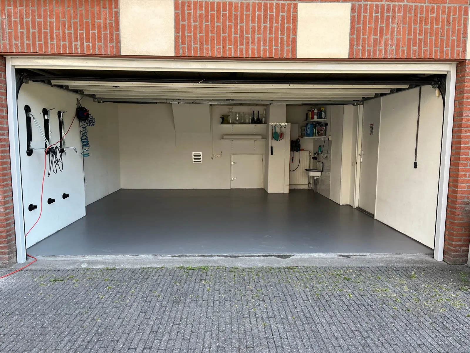Dezelfde garage na de coating met strakke grijze vloer